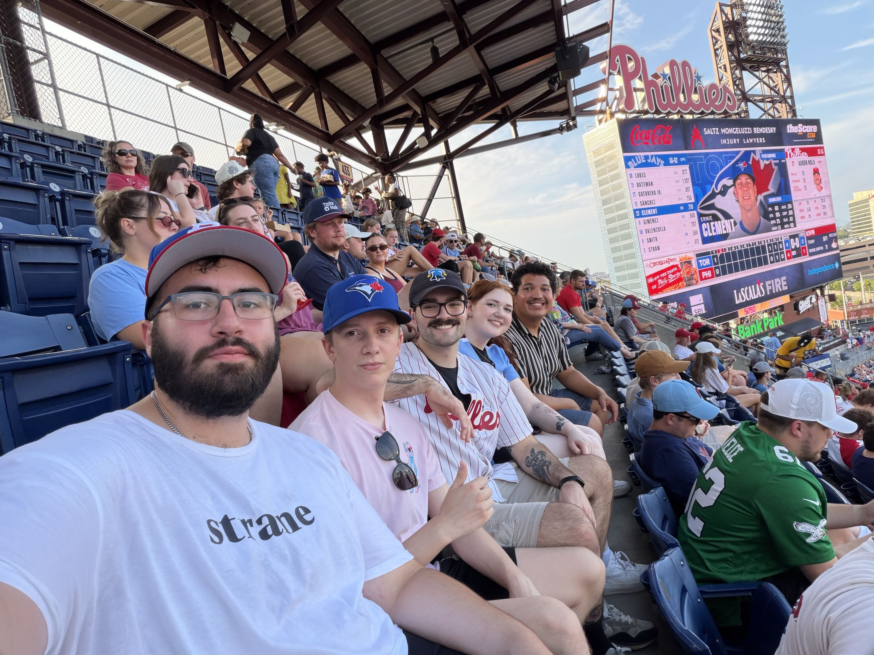 Me and my friends sitting down at a baseball game.